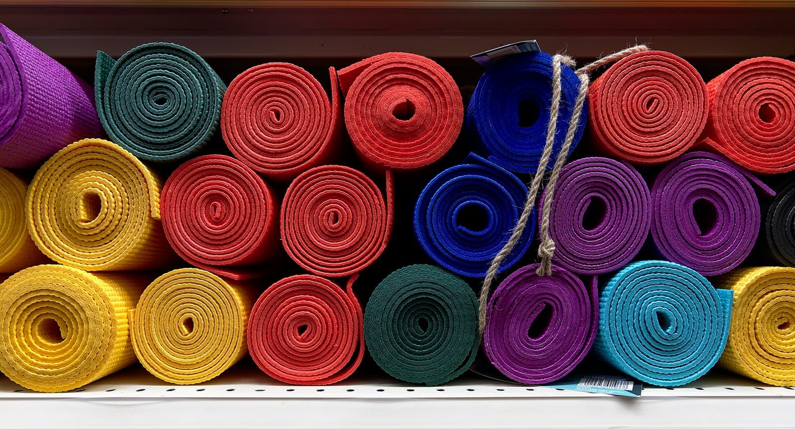 Rolled yoga mats stacked in a studio (CC BY-SA 2.0).